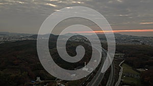 Flying over curved road toward distant hills with predawn color in sky