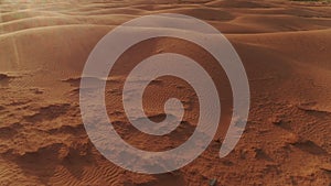 flying over the dunes in the desert at sunset, glare from the sun