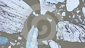 Flying over floating icebergs in Fjallsarlon glacial lagoon, Iceland. Aerial view of melting ice cap as result of global warming