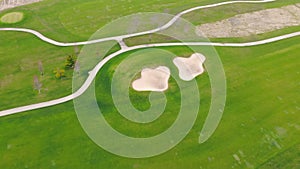 Flying over a golf course. Green lawn as a golf course with tracks.