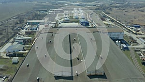 Flying over the hangars for the storage of grain, industrial buildings, aerial shooting from the copter