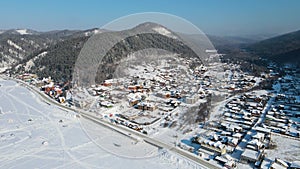 Flying over the highway at foot of hills. The shore of lake on clear winter day