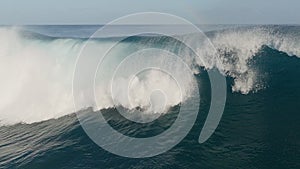 Flying over huge wave in atlantic ocean. Aerial filming breaking surf with foam. Powerful stormy sea or ocean waves