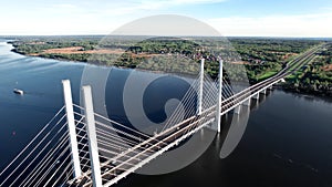 Flying over industrial bridge crossing river sea floating ship movement transportation aerial view