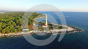 Flying over lighthouse, Croatia with a motorboat passing by