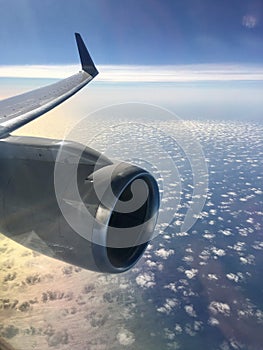 Flying over the ocean view of aircraft wing and clouds
