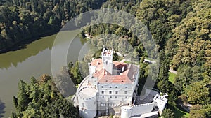 Flying over and old castle surrounded by a lake