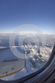 Flying over partially cloudy sky during the day.