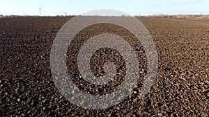 Flying over plowed fields of black soil on sunny autumn day. Fields black soil