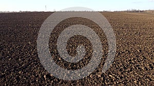 Flying over plowed fields of black soil on sunny autumn day. Fields black soil