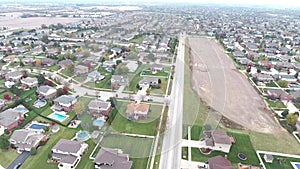 Flying over residential houses and yards along suburban street