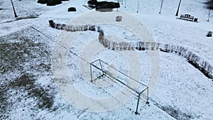 Flying over a sports field in a snow-covered city park. Aerial photography.