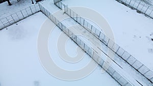 Flying over a sports field in a snow-covered city park. Aerial photography.