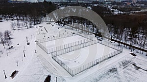 Flying over a sports field in a snow-covered city park. Aerial photography