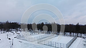 Flying over a sports field in a snow-covered city park. Aerial photography