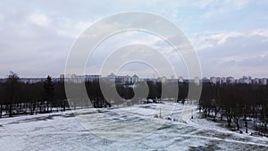 Flying over a sports field in a snow-covered city park. Aerial photography