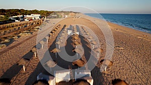 Flying over straw parasols at low altitude in Quarteira, Algarve, Portugal