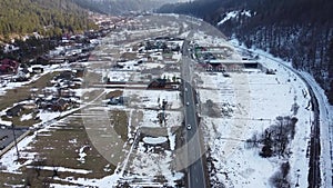 Flying over the valley, a village in the mountains. Overview of the river, road, railway, village, home. Carpathians