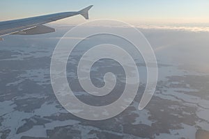 Flying over white snowy landscape with many forests in Finland