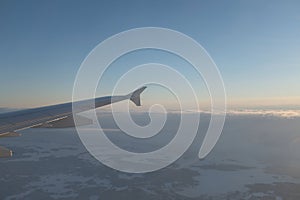 Flying over white snowy landscape with many forests in Finland sunset landscape