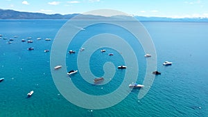 flying over yachts and motorboats parked not far from the shore on Lake Tahoe in California. Big lake and tourist motor