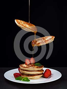 Flying pancakes with honey and strawberries.