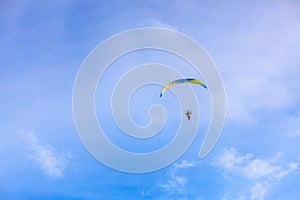 A flying paramotor on a vibrant sky with cloud