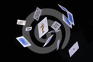 Flying poker cards on black background