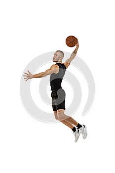 Flying. Portrait of basketball player jumping with ball isolated on white studio background. Sport, motion, activity