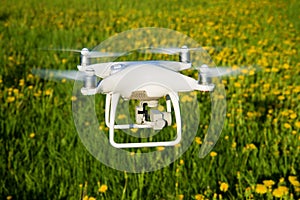 Flying quadrocopter close-up against summer meadow