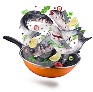 Flying seabass fishes with spices falling into a frying pan. Clipping path