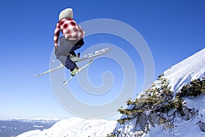 Flying skier at jump inhigh on mountains