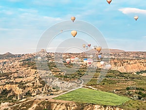 Flying in sky many bright colored beautiful balloons into air in Cappadocia in mountains early at sunrise, dawn. Filling