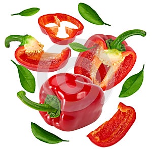 Flying sliced red sweet bell pepper with green leaves isolated on white background. clipping path