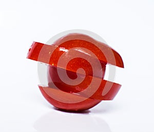 Flying slices of fruit: tomato on isolated white background.