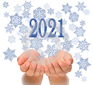 Flying snowflakes from womanâ€™s cupped hands with 2021 text, Happy New year 2021, 2021 New Year greeting card, happiness luck