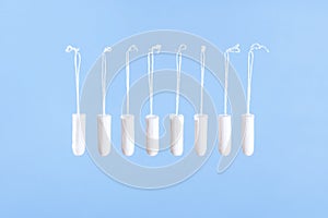 Flying tampons. Menstrual period concept. Woman hygiene protection. Women`s health. Cotton tampons on blue background. Front view