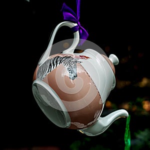 Flying teapot  on black background. Gravity concept, tea is pouring