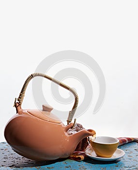 Flying teapot, tea cup. To pour tea. Drops. White background.