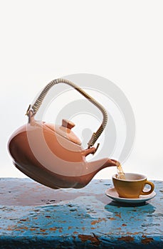 Flying teapot, tea cup. To pour tea. Drops. White background.