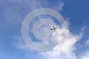 Flying turboprop plane on a background of blue sky