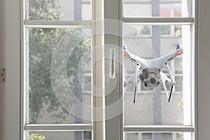 Flying white drone spying through window