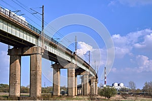A flyover with a railway line and a chimney of a heat and power plant photo