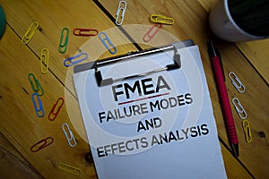 FMEA - Failure Modes and Effects Analysis write on a paperwork isolated on wooden background photo