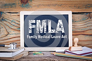 Fmla, family medical leave act. Chalkboard on a wooden background photo