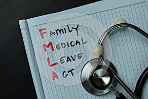 FMLA - Family Medical Leave Act write on a book isolated wooden table photo