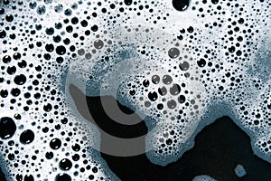 Foam air bubbles on black background photo