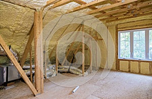 Foam plastic insulation installed in the sloping attic of new frame house