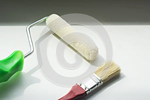 Foam roller and brush for painting on white background. Minimal construction concept