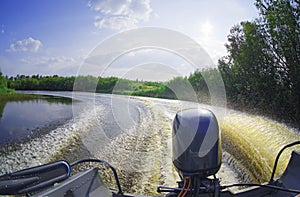 Foam and spray on surface of water behind a high-speed motor boat